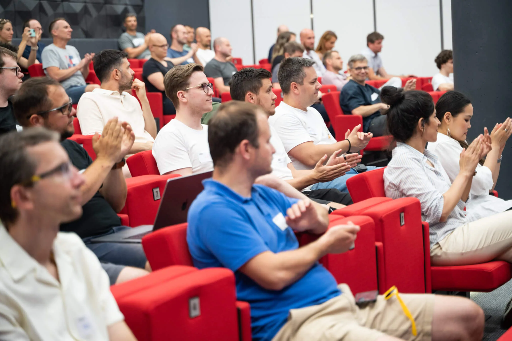 Auditorium of engineering leaders in red seats applauding after a talk at an ELC event