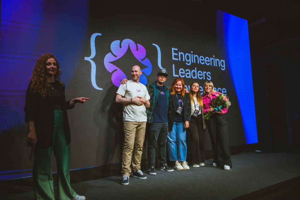 The core team of the Engineering Leaders Community (ELC) standing together on stage during the ELC 2025 conference, smiling and acknowledging the audience in a packed event hall.