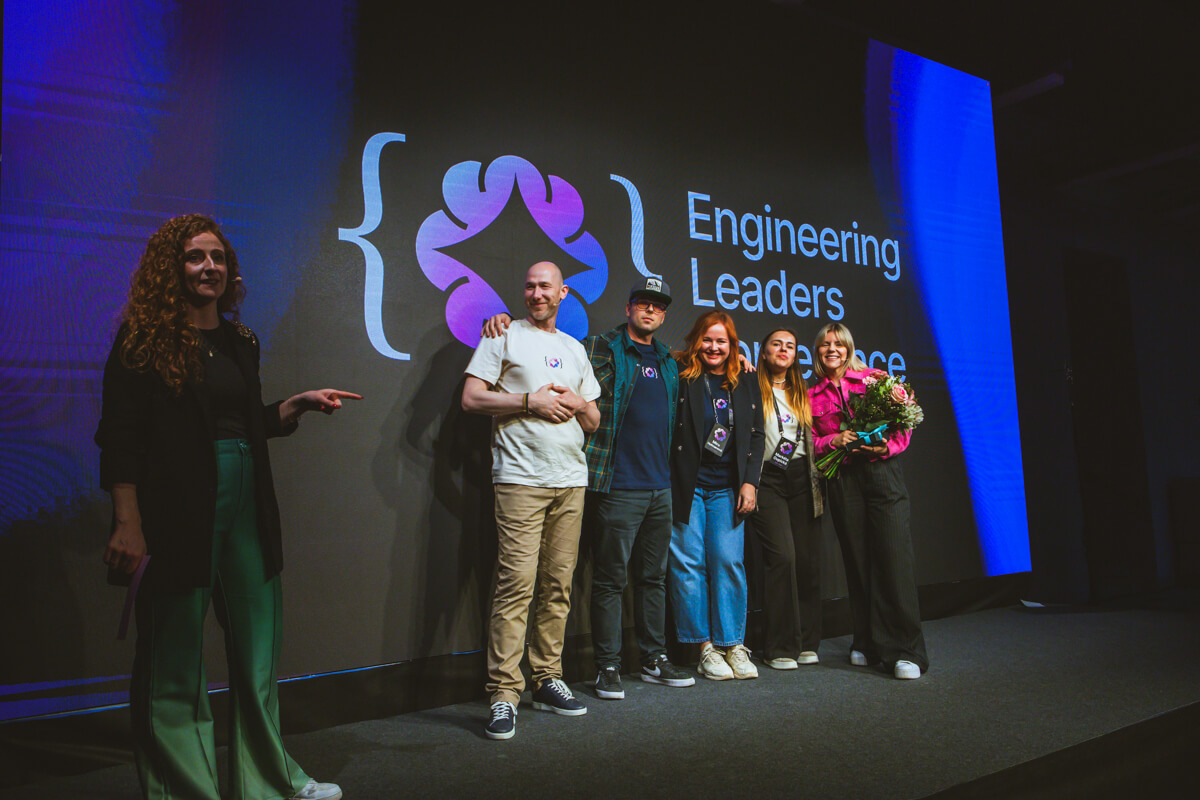 The core team of the Engineering Leaders Community (ELC) standing together on stage during the ELC 2025 conference, smiling and acknowledging the audience in a packed event hall.